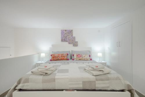 ein weißes Schlafzimmer mit einem großen Bett mit zwei Lampen in der Unterkunft MIRANDA APARTMENTS nel cuore del Vomero in Neapel