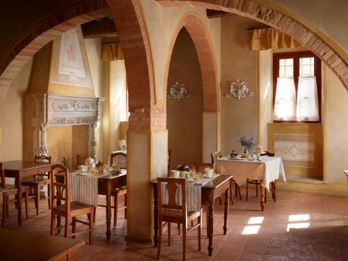 a dining room with tables and chairs in a building at B&B Borgo Petrognano - Residenza d'Epoca in Barberino di Val dʼElsa
