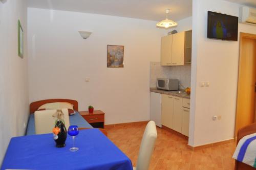 een keuken en een tafel met een blauwe tafeldoek bij Apartments Ivica in Makarska