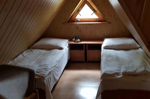 a attic room with two beds and a window at Willa Końiczynka in Zakopane