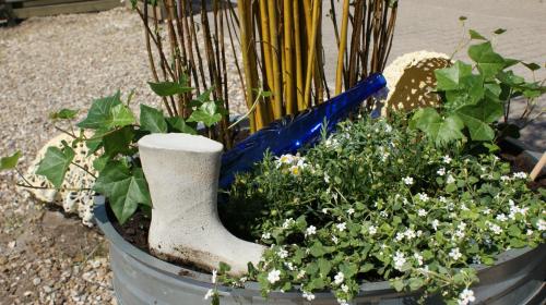 a planter with flowers and plants in it at Hyggeligt byhus ved glasværkstedet på Nordmors in Sejerslev