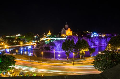 a city lit up at night with traffic on a street at King Gorgasali in Tbilisi City