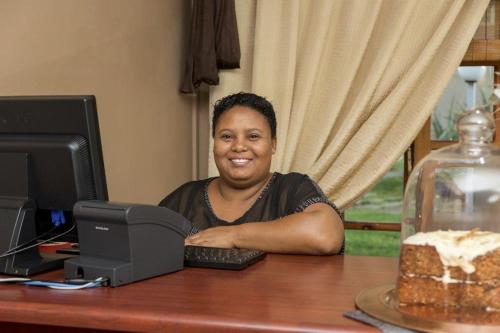 a woman sitting at a desk with a computer at Augrabies Falls Lodge & Camp in Augrabies
