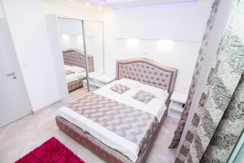 a bedroom with a large bed and a mirror at Apartman M.E.P. in Split