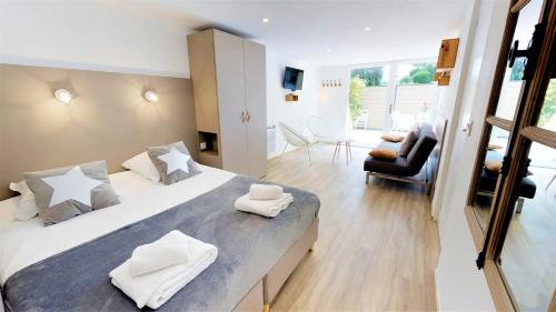 una camera da letto con un grande letto con asciugamani bianchi di L'EFFERVESCENT a Saint-Péray