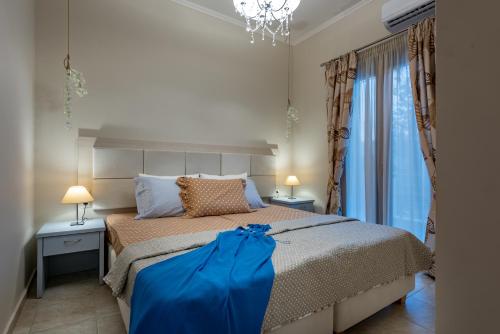 a bedroom with a large bed with a blue item on it at Aquarella Luxury Apartment in Argasi