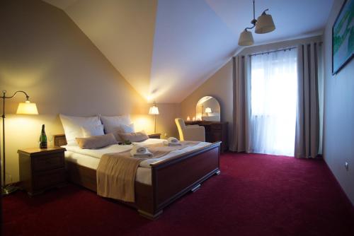 sypialnia z dużym łóżkiem i oknem w obiekcie Hotel Karino Spa w Polańczyku