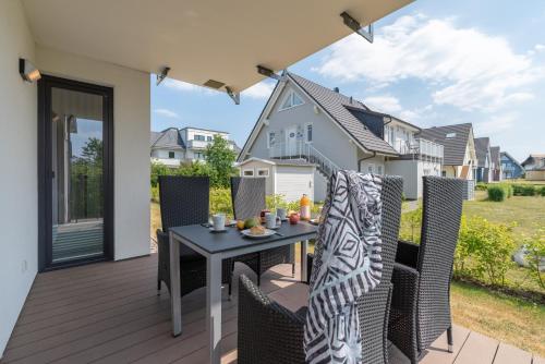 eine Terrasse mit einem Tisch und Stühlen auf einer Terrasse in der Unterkunft Seeresidenz in Börgerende-Rethwisch