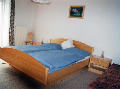 a bedroom with a wooden bed with a blue blanket at Ferienwohnung Christine Spiessberger in Gmundnerberg
