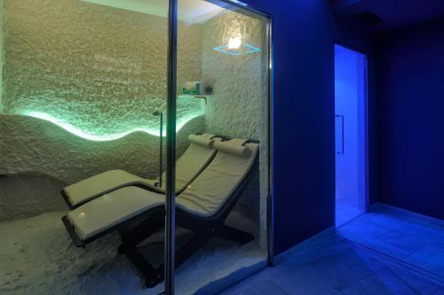 a bathroom with a chair in a glass shower at Hotel De Paris Sanremo in Sanremo