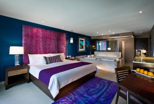 a bedroom with a large bed and a living room at Hard Rock Hotel Cancun - All Inclusive in Cancún