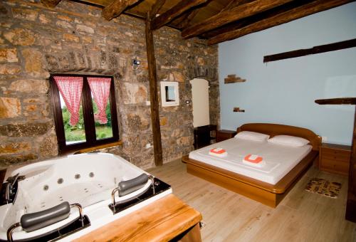 a bathroom with a tub and a bed in a room at Casa Storia & Casa Antica in Veprinac