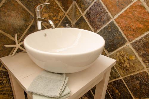 a white sink on a table in a bathroom at Sundowner Loft in Mossel Bay