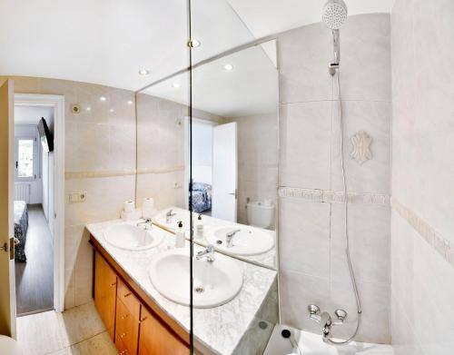 a bathroom with two sinks and a shower at Sèquia Deluxe Apartment in Girona