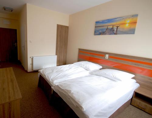 a bedroom with a bed with a painting on the wall at Hotel - Restauracja "SŁONECZNA" in Jarocin