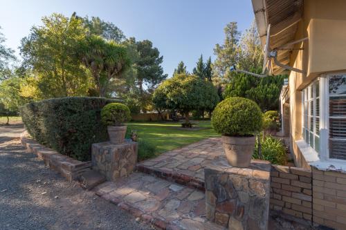 a house with a brick walkway next to a yard at GaMamadi Guest Farm in Nelspoort