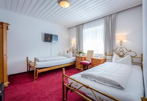 a hotel room with two beds and a window at Laimer Hof am Schloss Nymphenburg in Munich