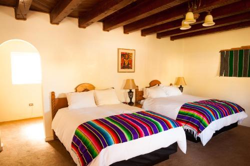 two beds in a room with two beds sidx sidx sidx sidx at El Pueblo Lodge in Taos