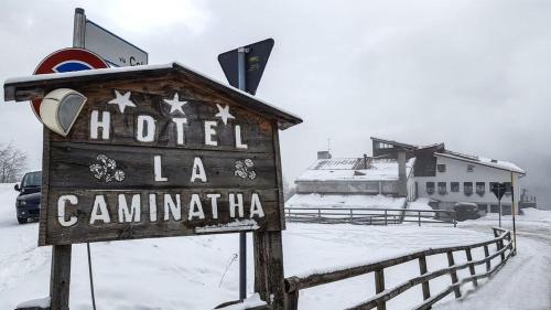 a sign for a hotel la canaminilla in the snow at HG Hotel La Caminatha in Val di Zoldo