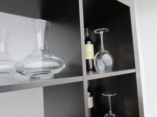 a cabinet with wine bottles and glasses on it at Hotel Sonderborg in Schrobenhausen