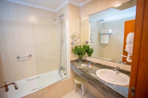Un baño con lavabo, ducha y espejo. en Hotel Don Pablo, en Gandía