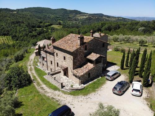 an old house with two cars parked in front of it at The Sanctuary by Caimeli in Umbertide