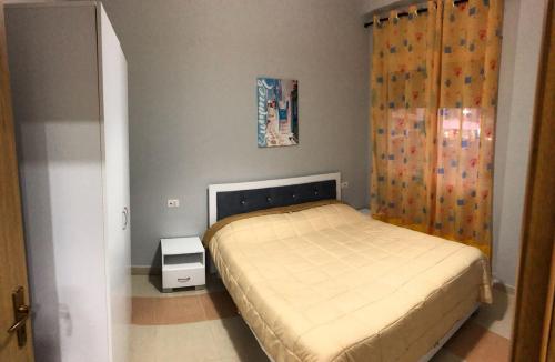 Habitación pequeña con cama y cortina en Seaside apartment N 2 Golem, en Golem