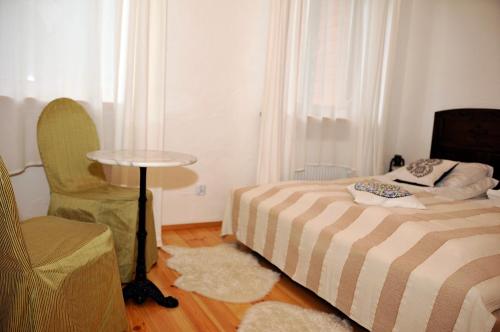 a bedroom with a bed and a chair and a table at Dom nad Rozlewiskiem in Zamość