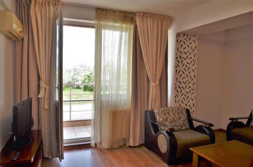 a living room with a chair and a large window at Denis Summer in Mamaia