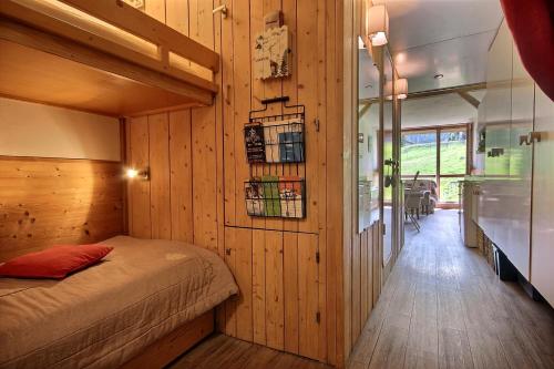 a bedroom with a bed in a wooden wall at ARC 1800 Pierra Menta in Arc 1800