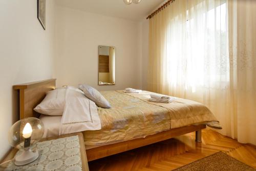 sypialnia z dużym łóżkiem i oknem w obiekcie Villa Rosi w Krku