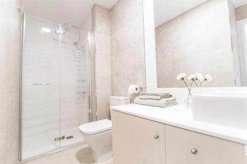 a white bathroom with a shower and a toilet at Elegant retreat business district Bernabéu in Madrid
