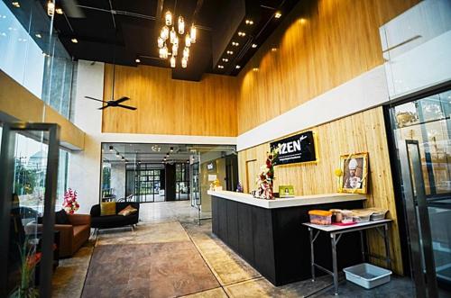 a lobby of a building with a bar in it at Izen Plus Budget Hotel & Residence in Rayong