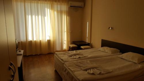 a hotel room with two beds and a window at Hotel Seasons 2 in Sunny Beach