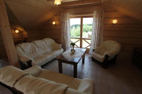 a living room with two white couches and a table at Apartamenty Osowa nad jeziorem Okmin in Suwałki