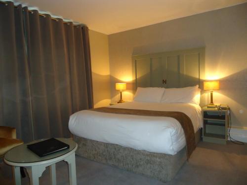 een hotelkamer met een groot bed en een tafel bij Templemore Arms Hotel in Templemore