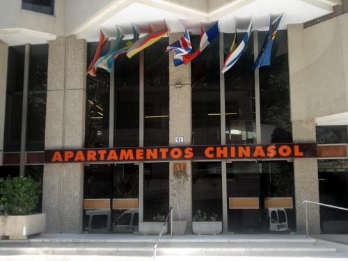 a sign in front of a building with flags at Apartamentos Chinasol in Almuñécar