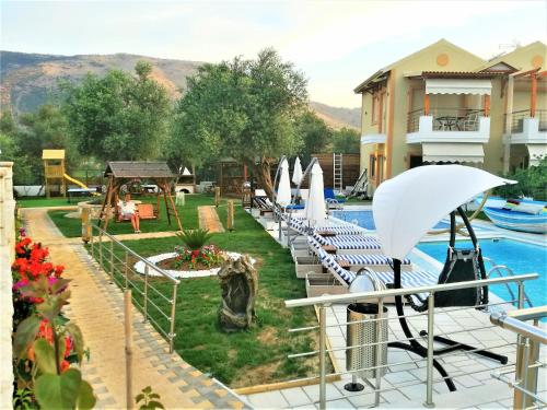 a pool with lounge chairs and umbrellas at a hotel at All Saints Villas in Plataria