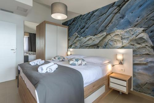 a bedroom with a large bed with towels on it at Apartments Vila 4m in Ražanac