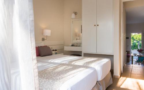a bedroom with a large white bed in a room at Blue Sky Apartments in Malia