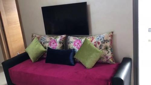 a couch with four pillows on top of it at Blanca Beach vue latérale sur mer in Sidi Rahal