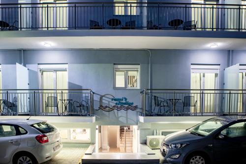 two cars parked in a parking lot in front of a building at Remis Studios in Rethymno Town