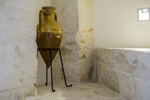 a large yellow vase sitting on a stand in a room at Dimora Lumi in Locorotondo