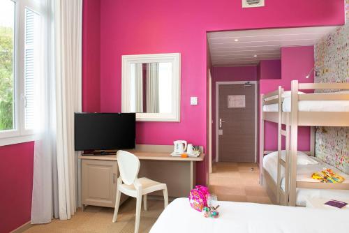 a bedroom with pink walls and a desk and bunk bed at Best Western Hotel Matisse in Sainte-Maxime