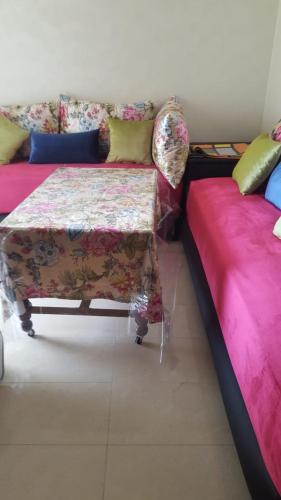a living room with a couch and a table at Blanca Beach vue latérale sur mer in Sidi Rahal