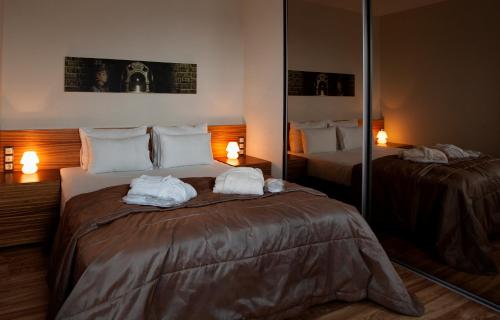 a hotel room with two beds with towels on them at Ararat All Suites Hotel Klaipeda in Klaipėda