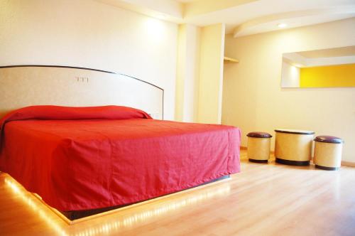 een slaapkamer met een rood bed en 2 vuilnisbakken bij Panorama Hotel  in Mexico-Stad