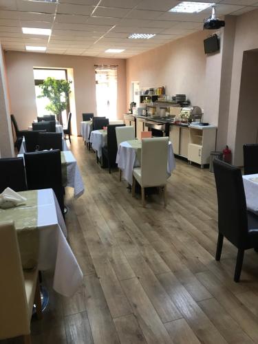 comedor con mesas y sillas y cocina en Pension Cleopatra, en Târgu Mureș