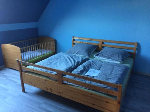 Schlafzimmer mit einem Holzbett mit blauen Wänden in der Unterkunft Haus Sonnenstein in Pirna