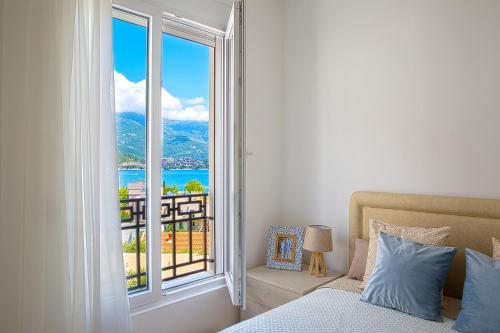 a bedroom with a bed and a large window at Chiron Apartments in Budva